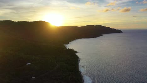 stunning sunset scene captured from above as the sun sets behind a lush coastal point in st. croix, usvi, bathing the shoreline and sea in warm, glowing hues of orange and pink