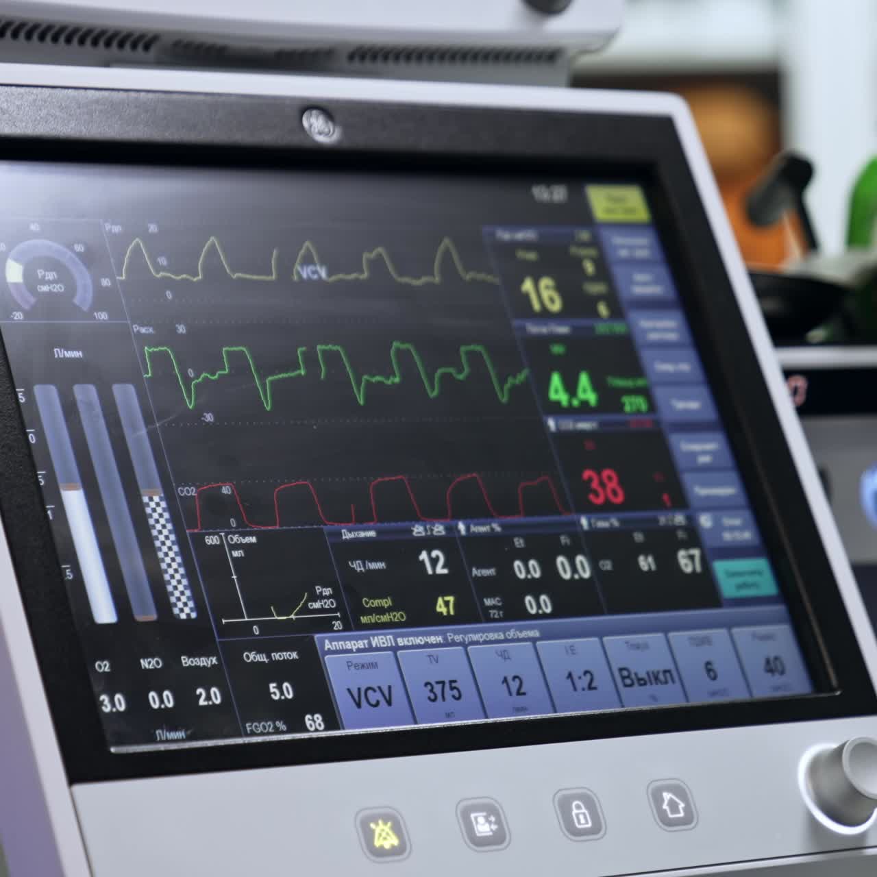 Screen of the mechanical lung ventilator. Unrecognized doctor stands looking at the monitor of equipment