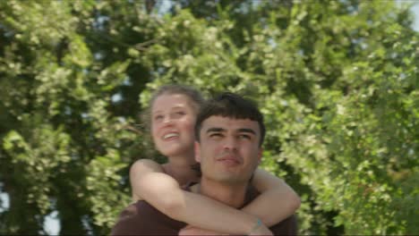 couple playing in the park, piggyback ride, having fun and laughter