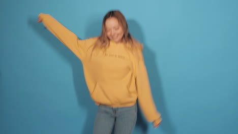 mujer feliz con capucha amarilla saltando