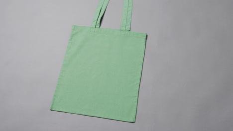 primer plano de una bolsa verde sobre un fondo gris, con espacio de copia, cámara lenta