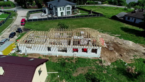 Aerial-view-around-a-roof-frame-at-a-house-construction-site,-summer-day