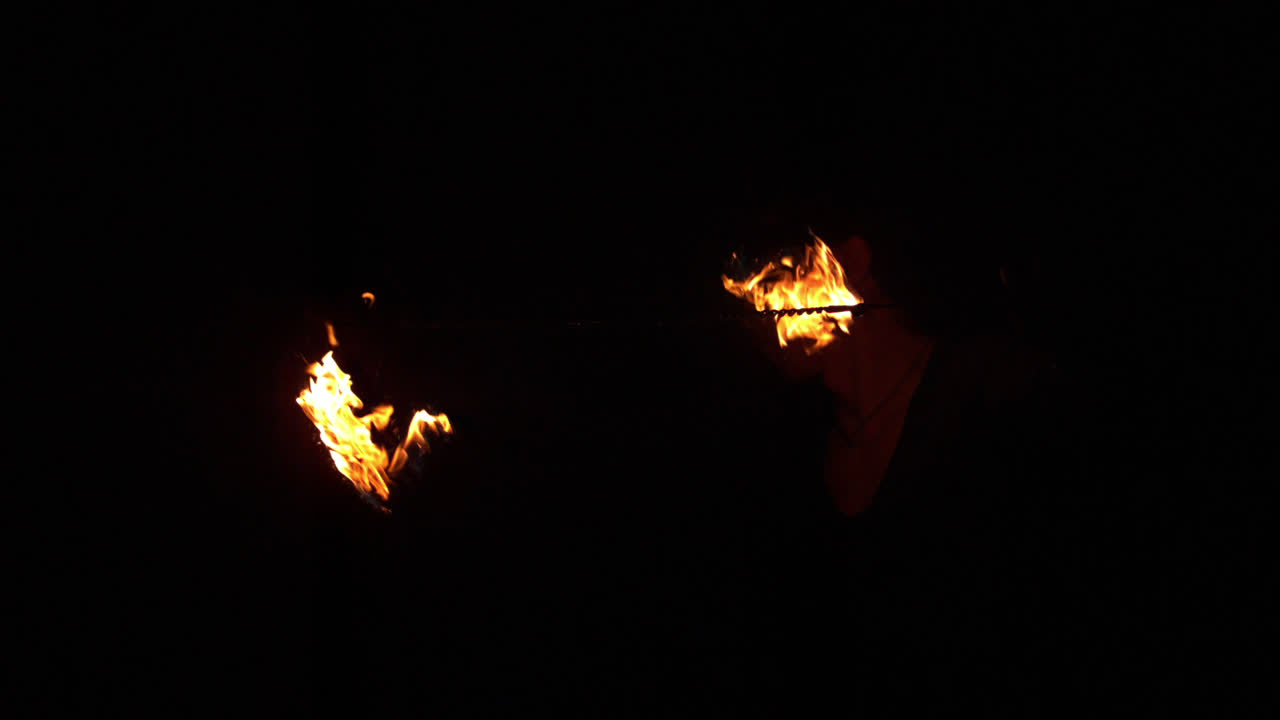 bailarina de fuego girando fuego en la oscuridad