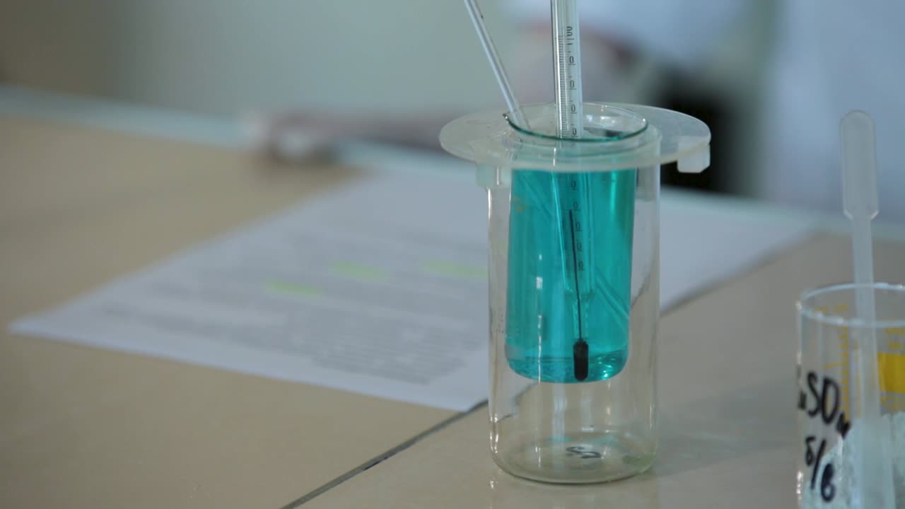 experimento de laboratorio con un vaso y un termómetro