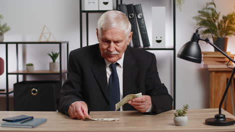 caucasian senior businessman in suit counting cash banknotes insufficient amount of money at home