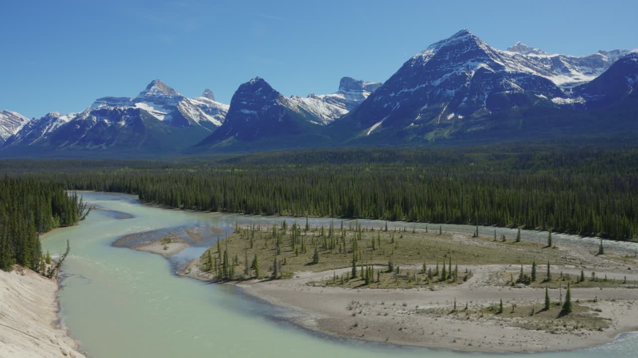 Athabasca-floden, der slynger sig gennem skove med snedækkede Rocky Mountains i Jasper Nationalpark, Canada