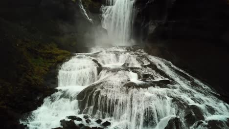 Aerial-rising-panoramic-drone-view-of-water-flowing-down-Ófærufoss-waterfall,-in-Iceland-highlands