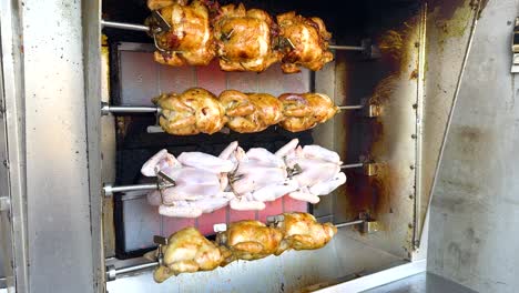 chickens roasting on a rotisserie in thailand