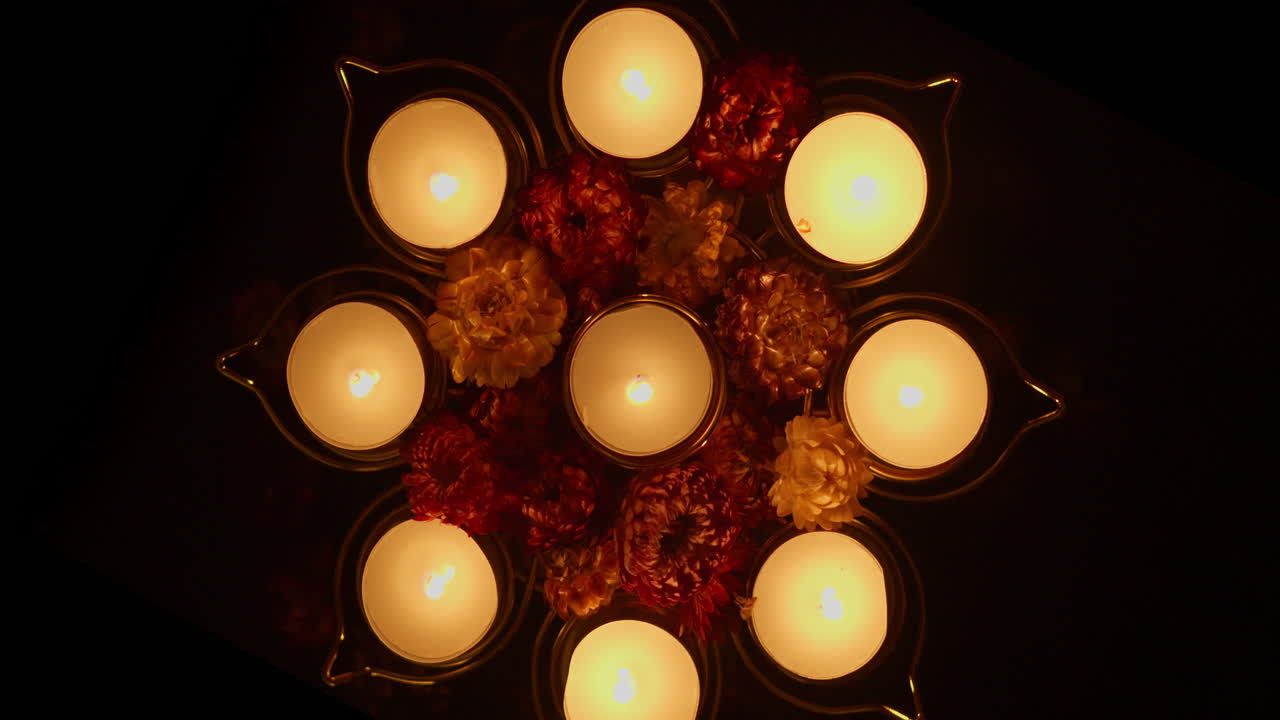 Mano che accende candele decorative e fiori per una celebrazione