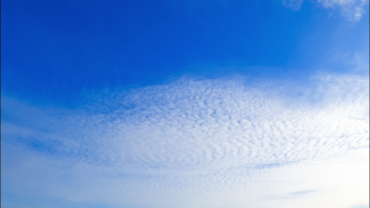 Light soft white cloudscape spreading around the horizon. Low angle view on the clouds floating in the sky.