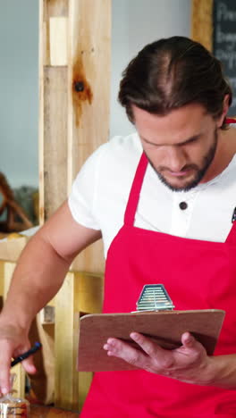 personal masculino haciendo una lista de comprobación en el mostrador de la panadería