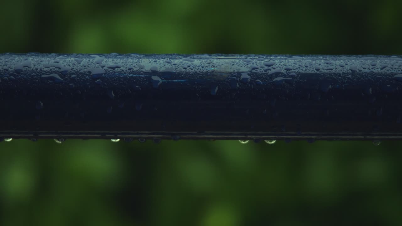 Rain drops forming on blue pipe due to heavy rain