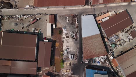 rusty roofs poor area industrial zone waste processing facility electronic waste e-waste, illegal e-waste shipping third world countries, toxic waste with negative environmental impact bird eye view