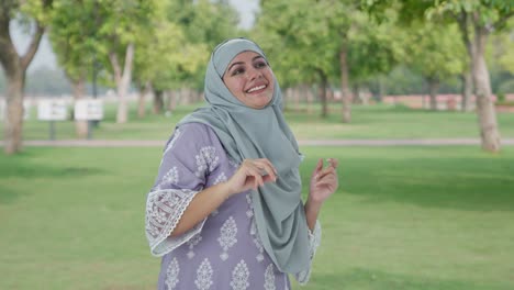 happy muslim woman dancing and enjoying in park