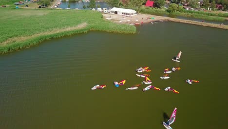 Toma-Aérea-De-Un-Entrenamiento-De-Windsurf-Para-Principiantes-En-Un-Lago-Tranquilo