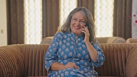 happy old indian woman talking on phone call