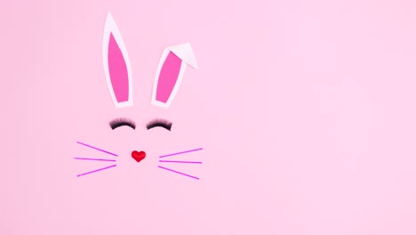 easter bunny blinking with eye lashes on pastel pink background. stop motion flay lay animation