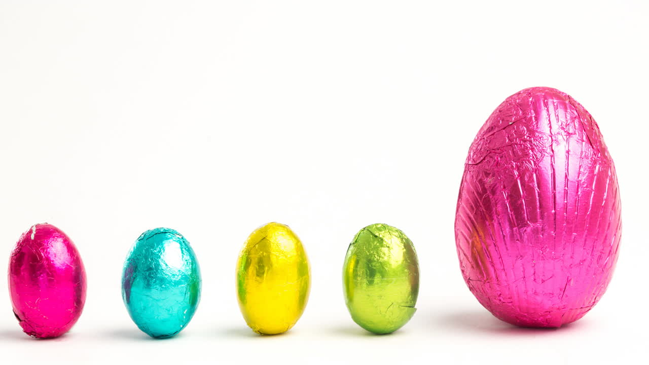 Animación de huevos de Pascua rosas, amarillos y azules sobre fondo blanco