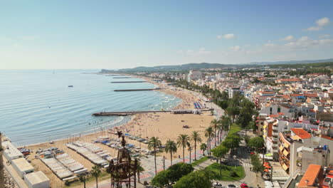 drone captures aerial footage of an ancient church overseeing a charming coastal town by azure sea on a sunny day