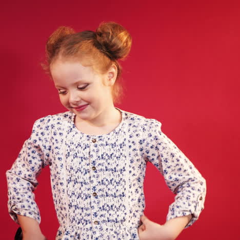 little cute little girl in the studio. cute redheaded child on red background