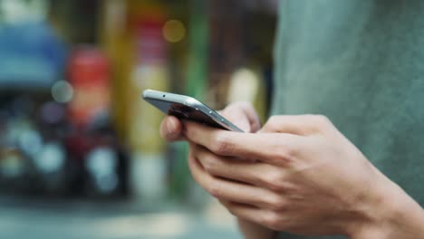 Handheld-view-of-man-browsing-his-mobile-phone