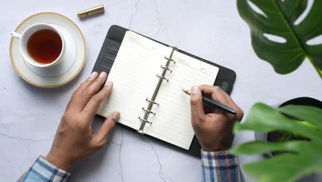 person planning with notebook and tea