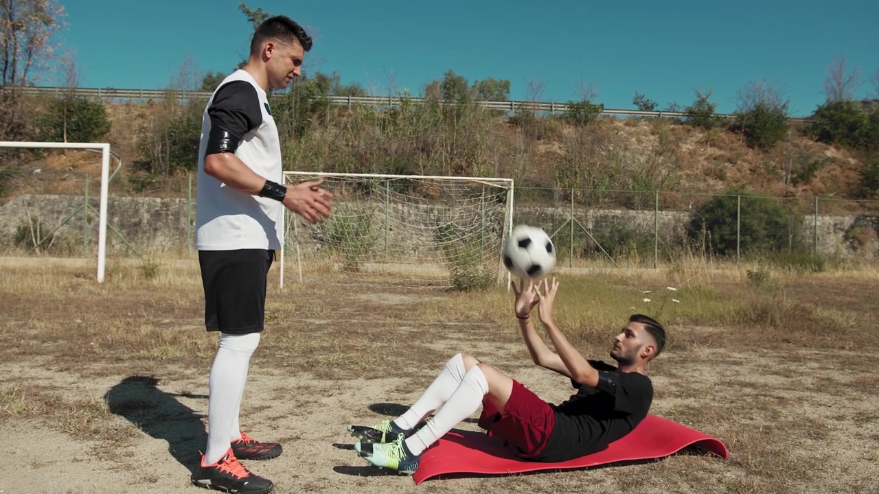 Two Players Helping Each Other Training With The Ball