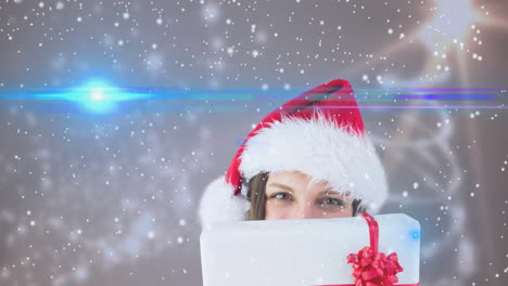 animation of snow falling over happy caucasian woman wearing santa hat keeping present