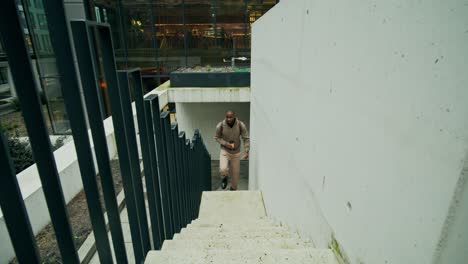 hombre subiendo escaleras en un entorno urbano moderno