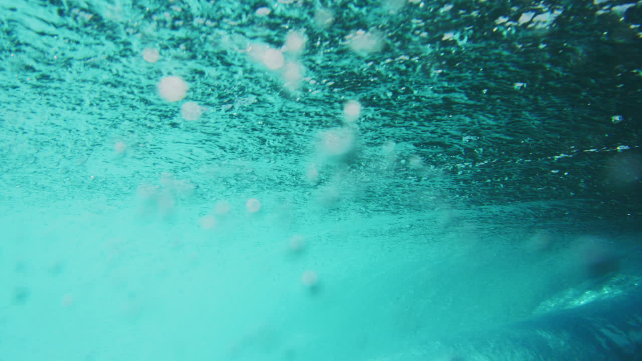 서퍼는 선을 내려서 은 바물 파도를 잡습니다.