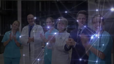 red de conexiones contra el equipo de profesionales médicos aplaudiendo en el hospital