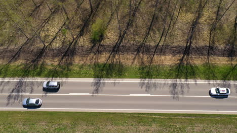 Aerial-shot-of-car-overtaking-another-vehicle-on-highway,-top-view-drone-pov-footage