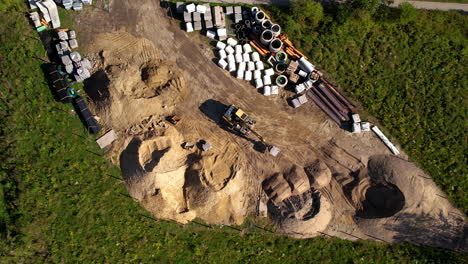 aerial top down - excavator working on a construction site - heavy equipment moving items - precise work with large tonnage