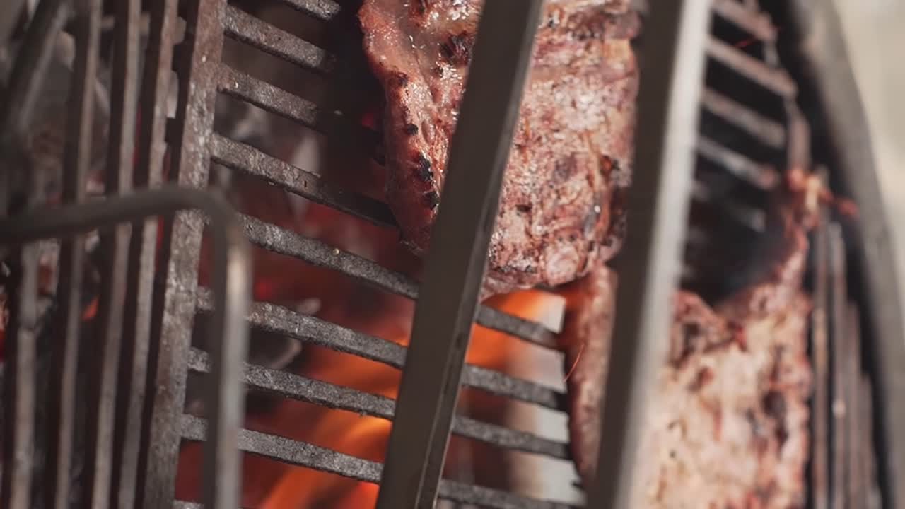 화염과 함께 불에 바비큐되는 집게로 고기를 돌립니다.