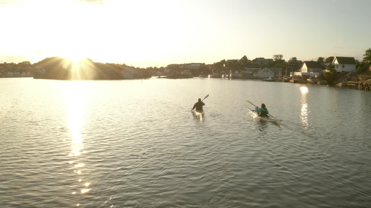 pareja remando kayac al atardecer