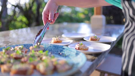 private chef plating appetizers at poolside dinner party smoked ahi crostini