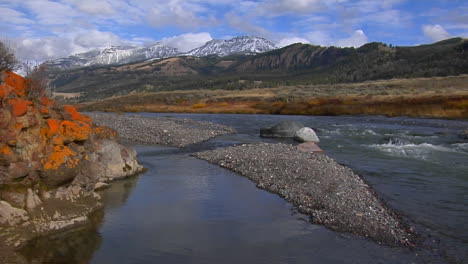 A-Small-Stream-Runs-Beneath-Snow-Covered-Mountains-In-Yellowstone-National-Park