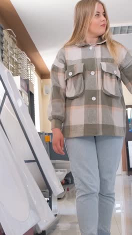 woman in a plaid jacket, light blue jeans, and sneakers in a bathroom products showroom