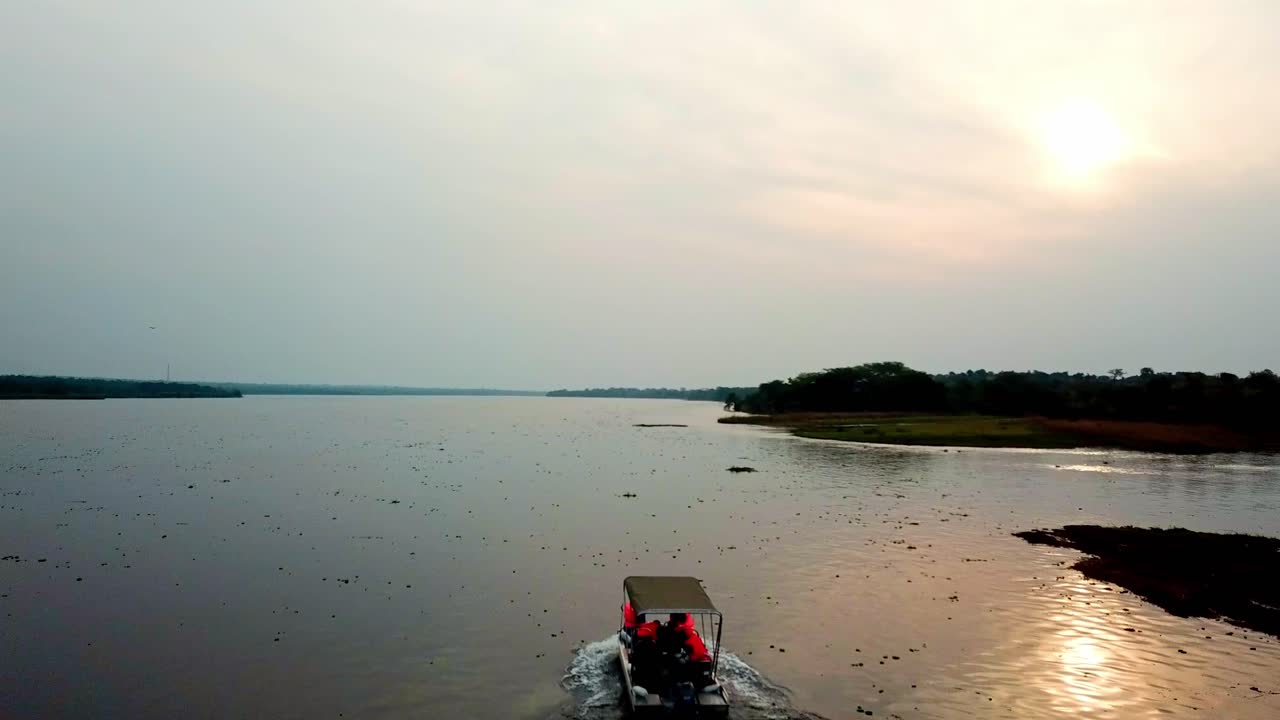 Tourists On A Boat Safari Tour In Chobe River At Sunset. River Cruise In Chobe National Park In Botswana, Africa. aerial tracking shot
