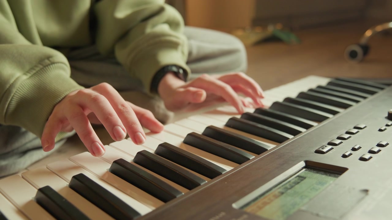 Low oblique close view of hands pressing keys on electronic keyboard in warm home studio, curved fingers showing subtle motion blur, focused touch, and flowing musical expression, with hand, keyboard