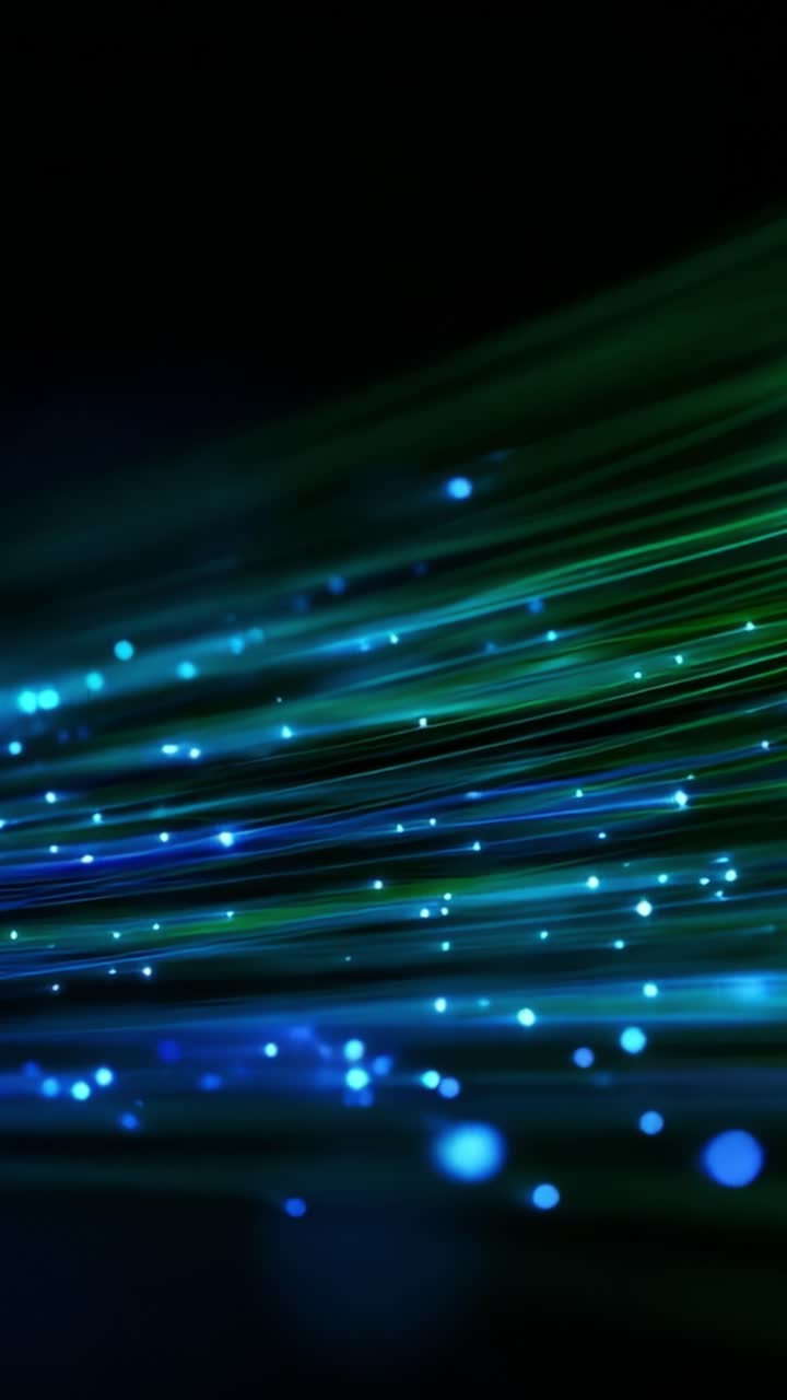Dynamic Waves of Colorful Light: An Abstract Representation of Fiber Optic Technology Glowing with Blue and Green Hues in Motion Over a Dark Background