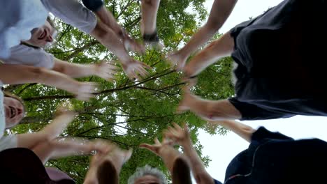 multi generational group of people place their hands together in a circle