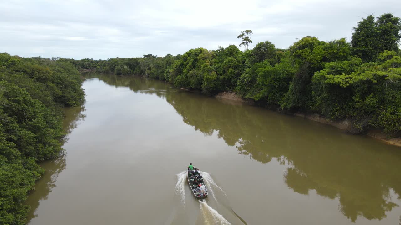 vista aérea de un barco en un río fangoso en lo profundo de la jungla de guyana, sudamérica, seguimiento de disparos de drones
