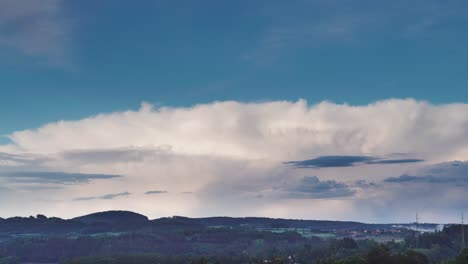 dramatic cloudscape over rural hills and distant village