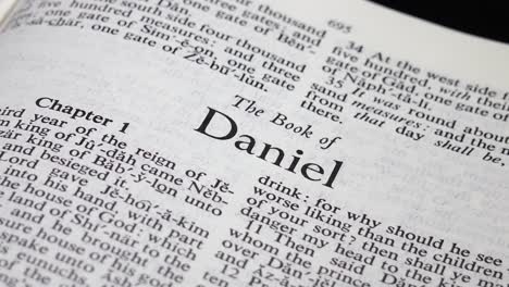 close up of bible page turning to the book of daniel