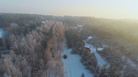 Toma-De-Un-Dron-De-Un-Automóvil-Conduciendo-En-Un-Bosque-Nevado