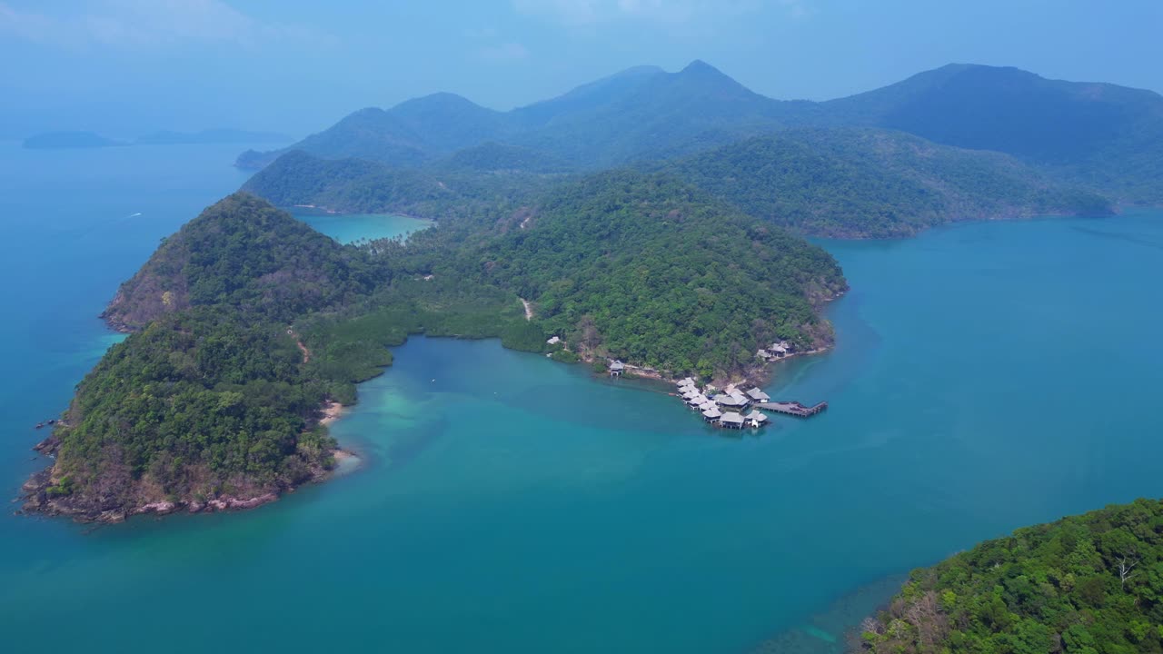 Koh Chang's Ko Ngam idyllic landscape, featuring lush greenery, a pristine beach, and a tranquil pier extending into the turquoise waters. Wonderful aerial view flight drone top down Above view