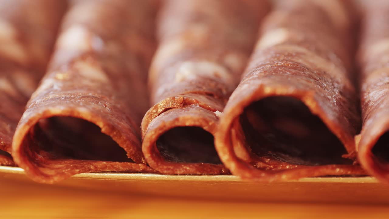 black bull sausage ham, tongue pork dry-cured sausage on a black background, traditional spanish delicatessen food, close up.