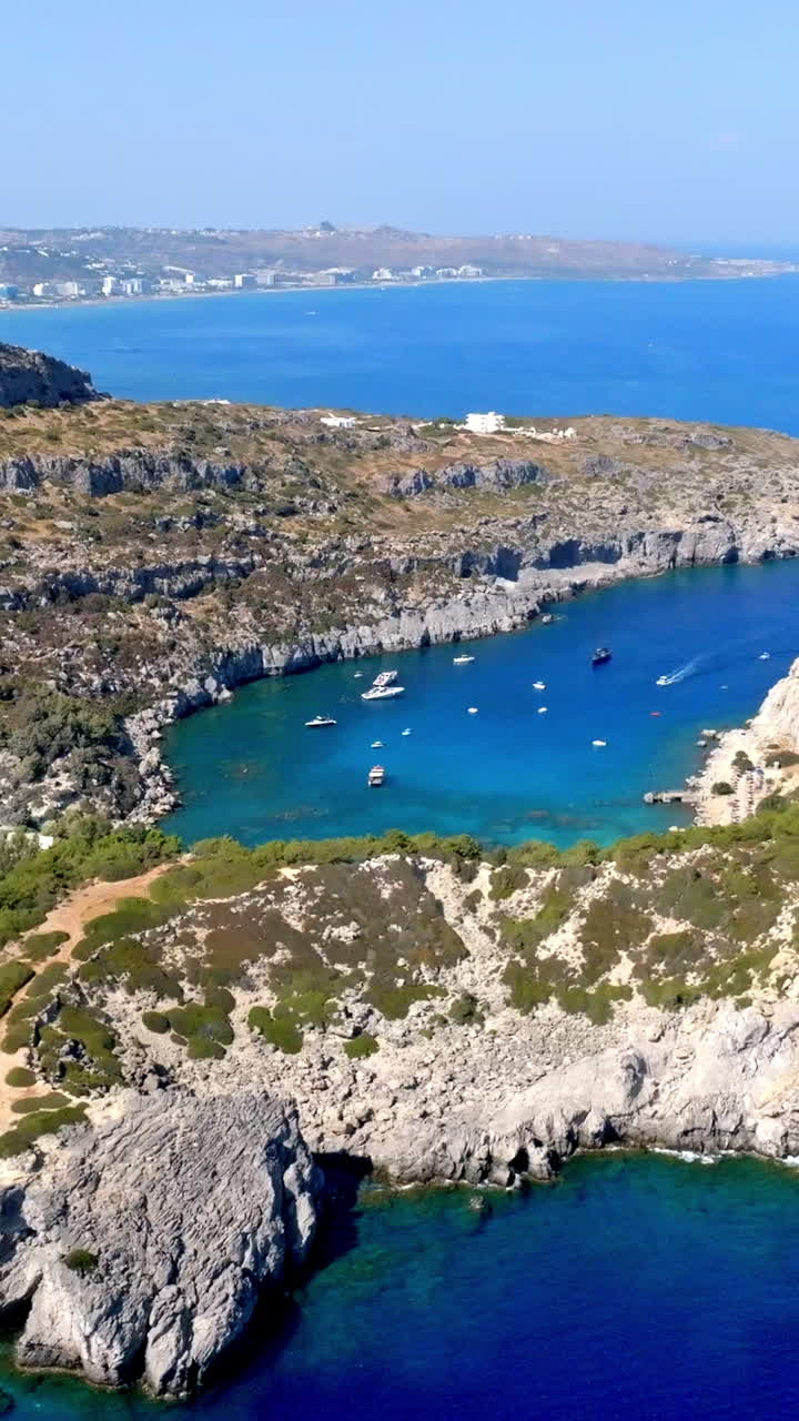 Vertical drone shot orbiting the Anthony Quinn bay, sunny day in Rhodes, Greece