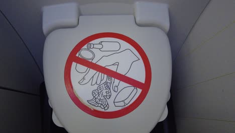 airplane bathroom closed lid with prohibited sign zoom in, onboard airplane interior 4k